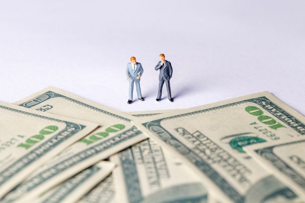 Miniature of investor man looking to money. Business and Investment concept.