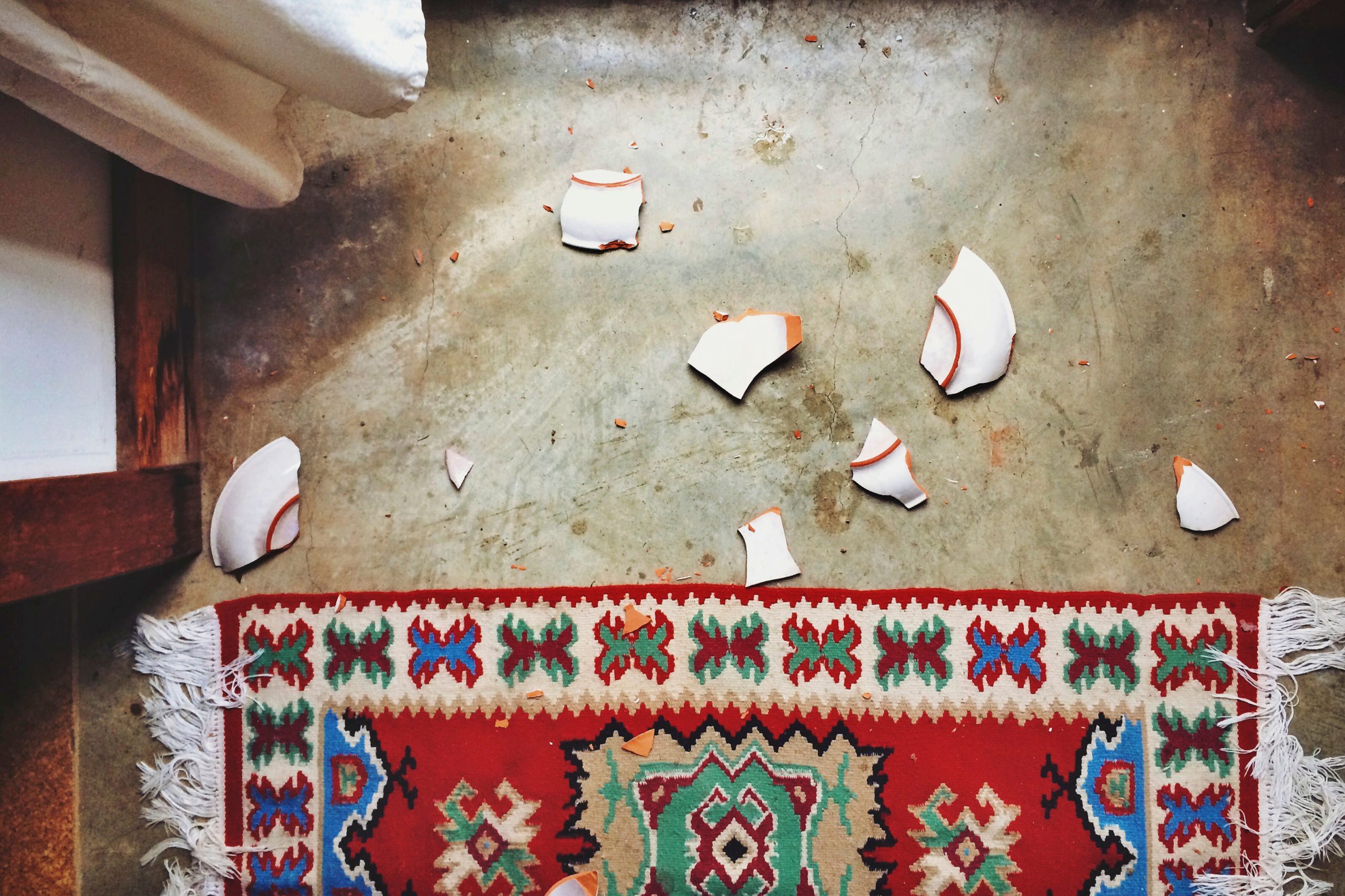 Directly Above Shot Of Broken Plate By Carpet At Home