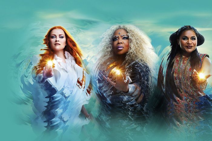 Three women project glowing light from their hands, surrounded by swirling colors, set against a turquoise sky backdrop.