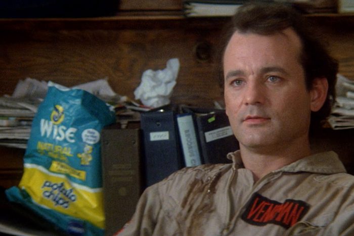 Man sitting calmly, wearing a jumpsuit labeled 
