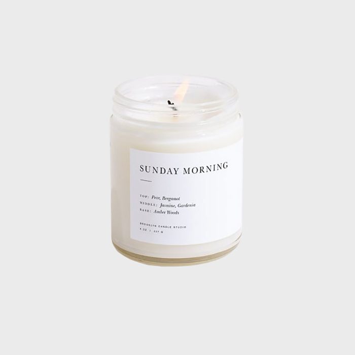 Candle burns inside a glass jar labeled 